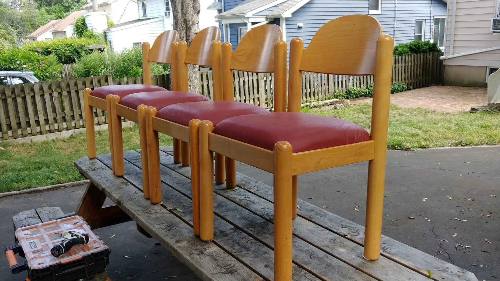 A set of four dining chairs with newly reupholstered red seats