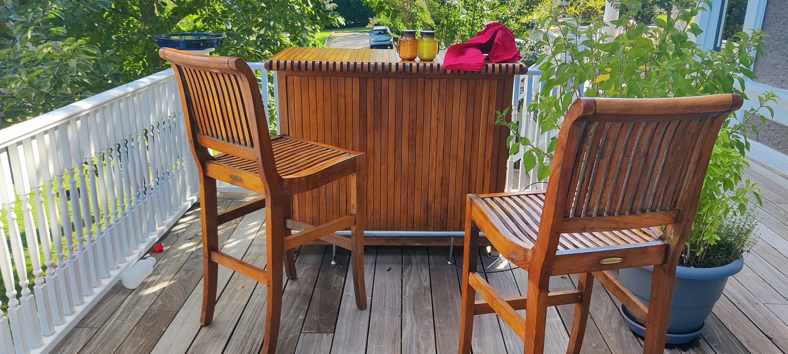 A refinished teak outdoor bar and stools on a deck