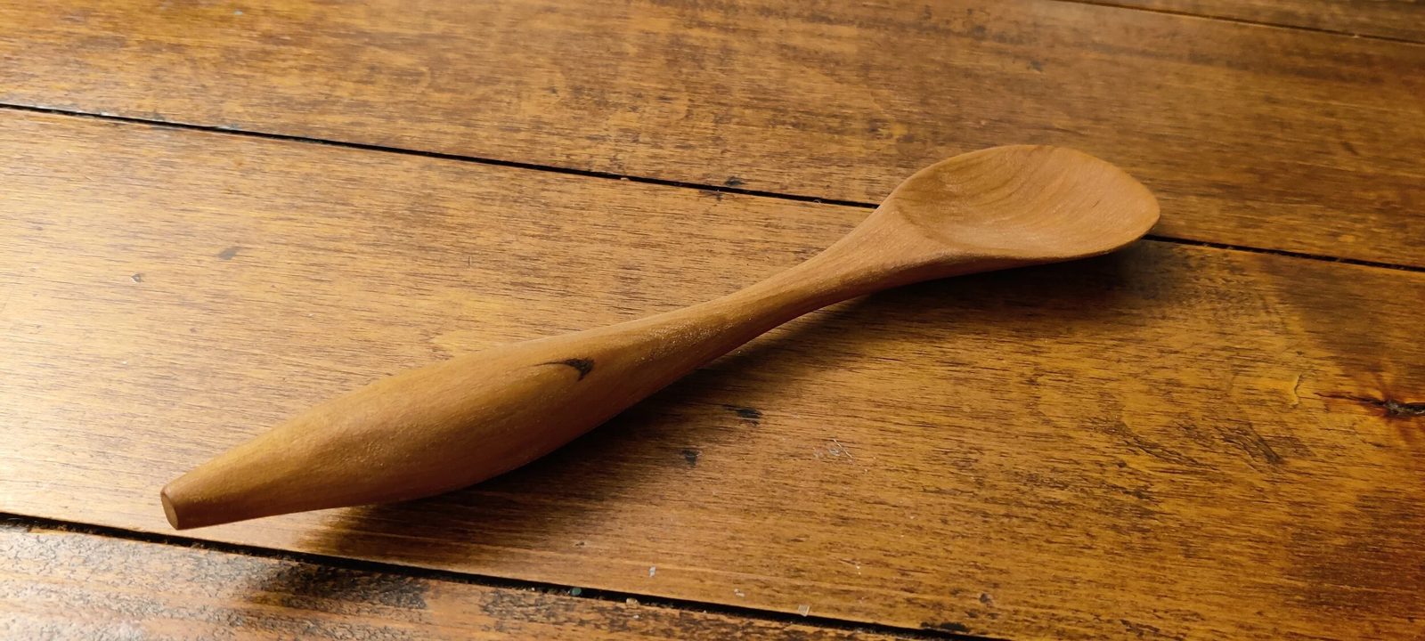 A hand-carved wooden spoon, handle detail